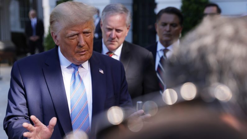 El presidente Donald Trump habla mientras el jefe de Gabinete de la Casa Blanca Mark Meadows, escucha afuera de la Casa Blanca en Washington el 29 de Julio de 2020. (Alex Wong/Getty Images)