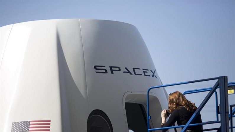 Una periodista toma fotos del exterior de una cápsula espacial de la empresa SpaceX. EFE/Armando Arorizo/Archivo
