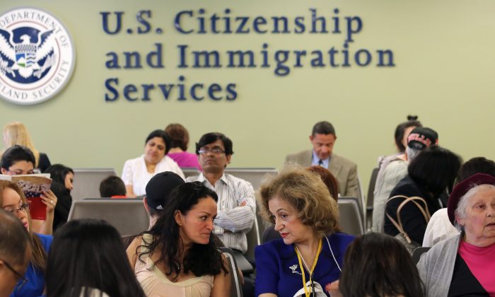 Unos inmigrantes esperan su turno de las entrevistas para obtener la tarjeta verde y su ciudadanía en la oficina del Servicio de Ciudadanía e Inmigración de los Estados Unidos en Queens, en el barrio de Long Island City de la ciudad de Nueva York, el 30 de mayo de 2013. (John Moore/Getty Images)