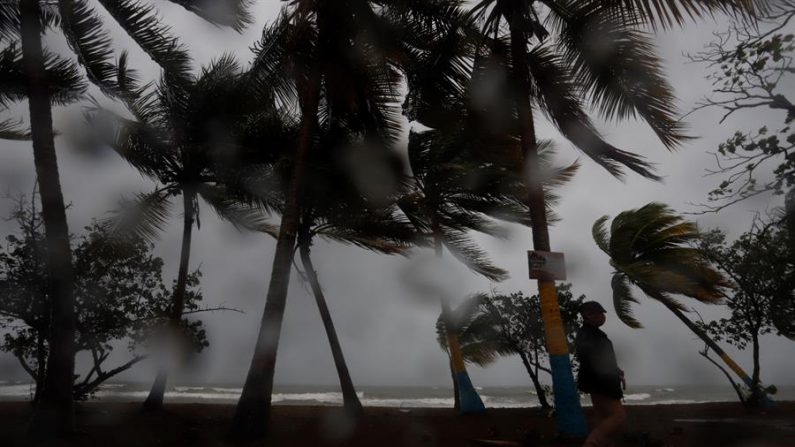 Una persona camina entre la lluvia y los fuertes vientos debido al paso de la tormenta Laura. EFE/Thais Llorca