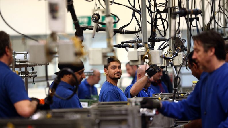 Un empleado trabaja en una línea de producción de motores en una fábrica de Ford el 13 de enero de 2015. (Carl Court/Getty Images)