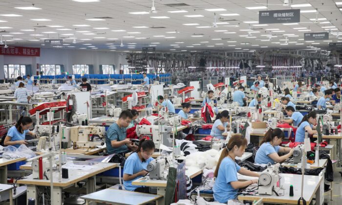 Los empleados producen abrigos de plumas en una fábrica para la empresa de ropa china Bosideng en Nantong, en la provincia oriental de Jiangsu, el 24 de septiembre de 2019 (STR/AFP a través de Getty Images)