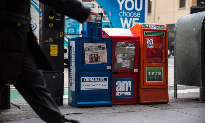 Una máquina de pago del periódico China Daily está junto a otros diarios gratuitos en el centro de Manhattan. Imagen de archivo el 6 de diciembre de 2017. (Benjamin Chasteen/The Epoch Times)