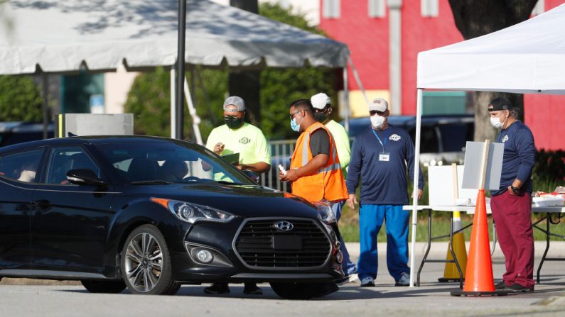 Los miembros del Equipo Estatal de Respuesta a Emergencias registran a los conductores para recibir una prueba de COVID-19 en el Complejo Maingate de Walt Disney World el 14 de agosto de 2020 en Kissimmee, Florida (EE.UU.). (Foto de Octavio Jones/Getty Images)