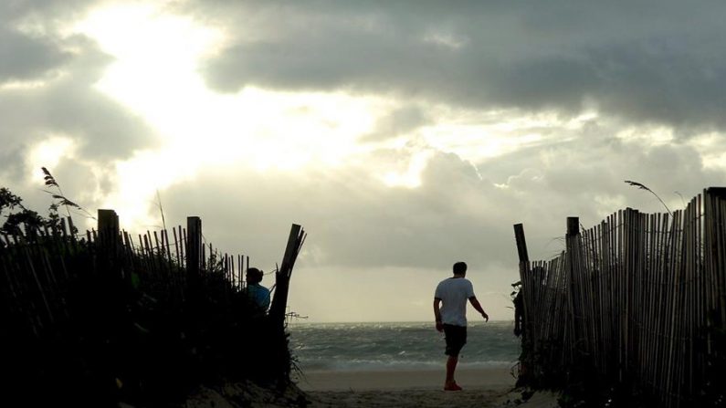Dos excursionistas pasean por la playa Sur de Miami mientras varias nubes cubren el cielo. EFE/CJ Gunther/Archivo