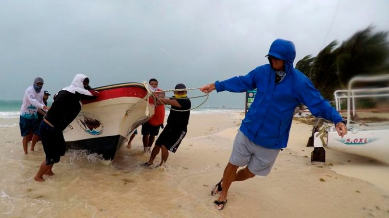 Pescadores retiran una embarcación al registrarse fuertes vientos en el sureste mexicano. EFE/Archivo