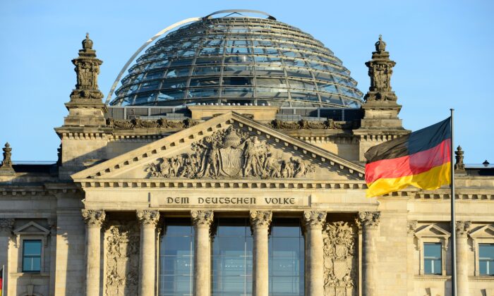 La bandera nacional alemana se ve frente al edificio del Reichstag que alberga el Parlamento alemán Bundestag el 16 de diciembre de 2013. (John Macdougall/AFP vía Getty Images)
