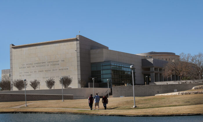 Los visitantes caminan a lo largo de una laguna detrás del Centro de la Biblioteca Presidencial George H.W. Bush en el campus de la Universidad Texas A&M en College Station, Texas, el 2 de diciembre de 2018 (Scott Olson/Getty Images)