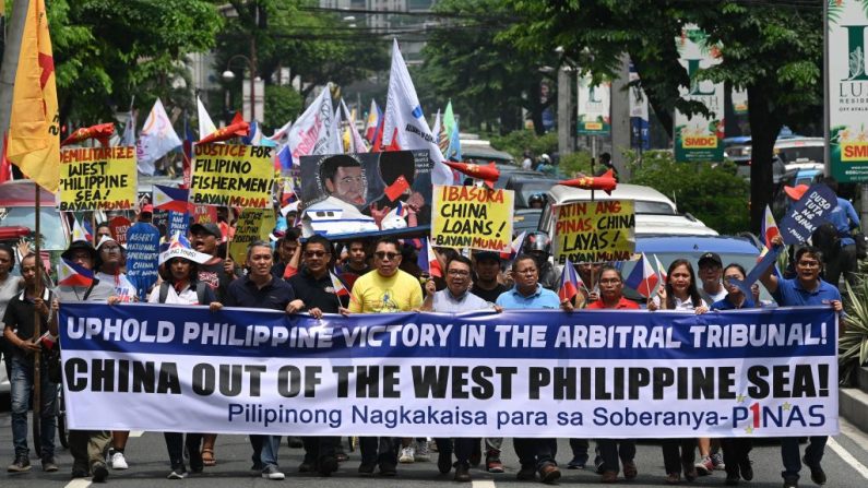 Manifestantes con una serpentina marchan hacia el consulado chino para una manifestación en Manila (Filipinas) el 13 de julio de 2019, coincidiendo con el aniversario de la decisión arbitral de las Naciones Unidas sobre el mar de China meridional. (TED ALJIBE / AFP a través de Getty Images)