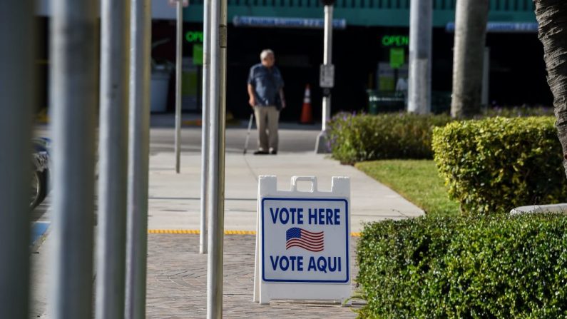 Un letrero se mantiene fuera de un colegio electoral desierto durante las elecciones primarias de Florida en el ayuntamiento de Miami Beach en Miami (EE.UU.), el 17 de marzo de 2020. (Foto de CHANDAN KHANNA/AFP vía Getty Images)