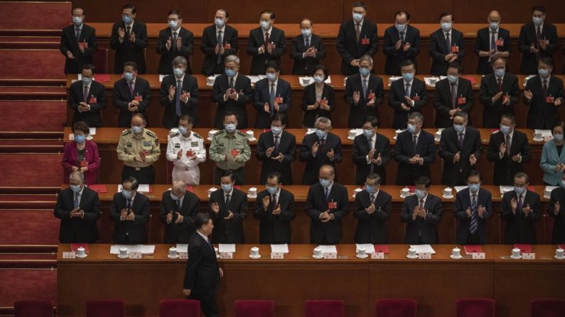 El líder chino Xi Jinping (abajo) llega a la sesión de clausura de la conferencia de la legislatura títere del régimen, mientras los demás funcionarios del Partido Comunista aplauden en Beijing, China, el 28 de mayo de 2020. (Kevin Frayer/Getty Images)