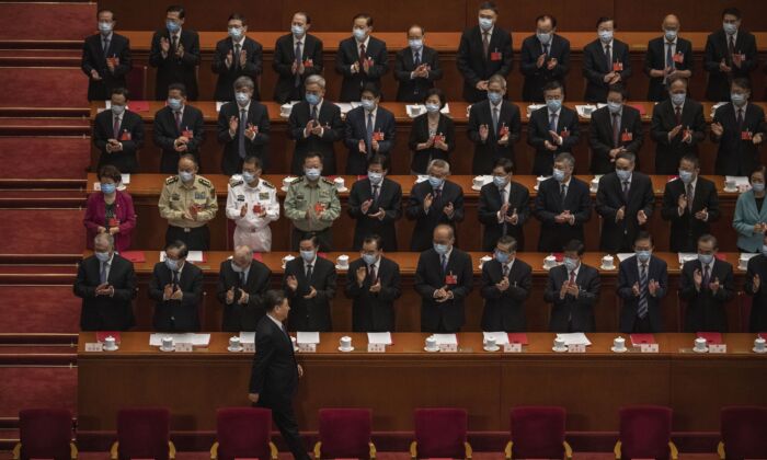 El líder chino Xi Jinping (abajo) llega a la sesión de clausura de la conferencia legislativa títere del régimen chino mientras otros funcionarios del Partido Comunista aplauden, en Beijing, el 28 de mayo de 2020 (Kevin Frayer/Getty Images)