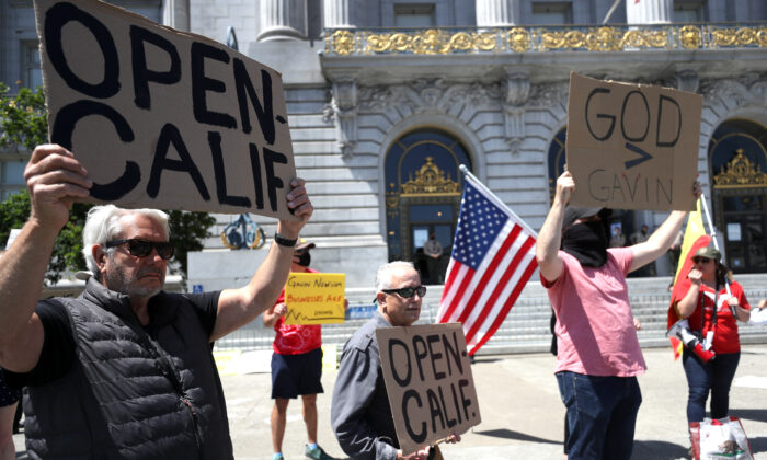 Los manifestantes protestan, al frente del Ayuntamiento de San Francisco, contra las ordenes estatales de confinamiento continuo impulsadas por el gobernador de California, Gavin Newsom, el 1 de mayo de 2020. (Justin Sullivan/Getty Images).