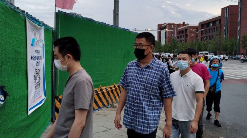 La gente usa mascarillas mientras espera en fila para someterse a las pruebas de hisopado del coronavirus COVID-19 en una estación de pruebas temporal en Beijing el 6 de julio de 2020. (Lintao Zhang/Getty Images)