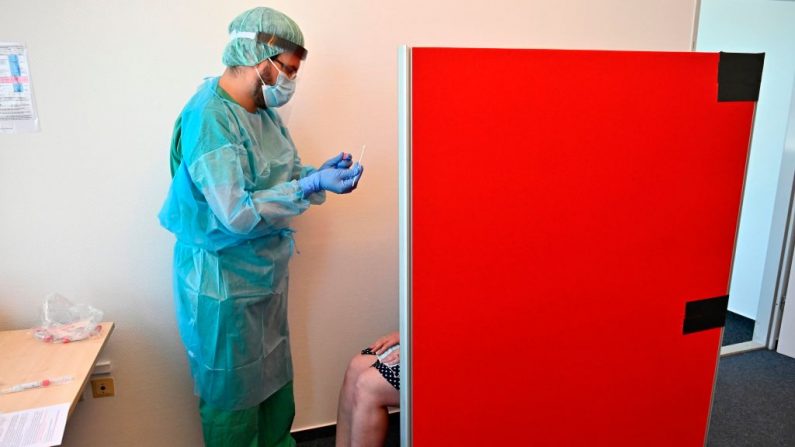 Un trabajador de la salud hace una prueba del nuevo virus causante del COVID-19 en el aeropuerto Berlín - Schoenefeld de Berlín, el 31 de julio de 2020
