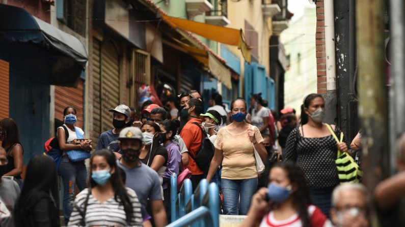 Las personas que usan máscaras protectoras se despiertan en el área comercial de Petare el 1 de agosto de 2020 en Caracas, Venezuela. (Foto de Carlos Becerra/Getty Images)