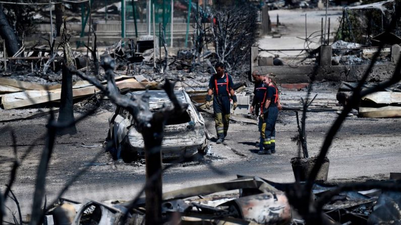 Bomberos franceses revisan un campamento quemado en La Couronne, cerca de Marsella, el 5 de agosto de 2020, devastado después de un incendio forestal. (Foto de CHRISTOPHE SIMON/AFP vía Getty Images)