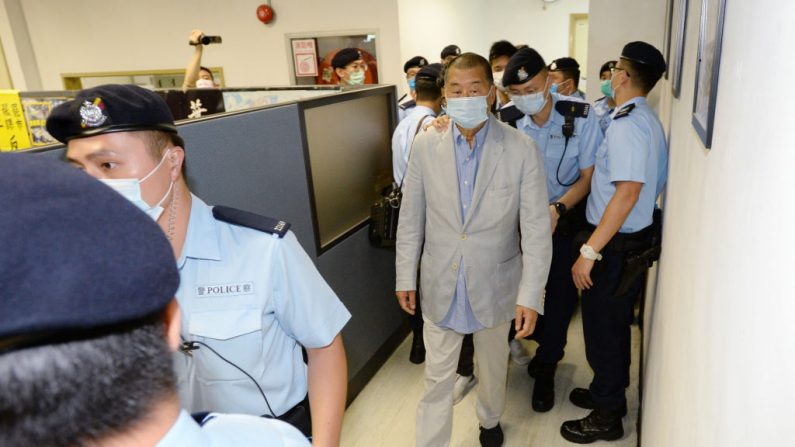 Una foto de Apple Daily muestra al magnate de los negocios de Hong Kong, Jimmy Lai, dirigido por oficiales de policía durante un allanamiento en la sede de Apple Daily, después de que Lai fuera arrestado en su casa el 10 de agosto de 2020, en Hong Kong, China. (Folleto/Getty Images)