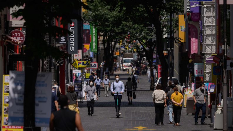 Peatones con mascarillas como medida de protección contra el COVID-19 caminan por el distrito comercial de Myeongdong en Seúl el 25 de agosto de 2020, Corea del Sur. (Ed Jones/AFP vía Getty Images)
