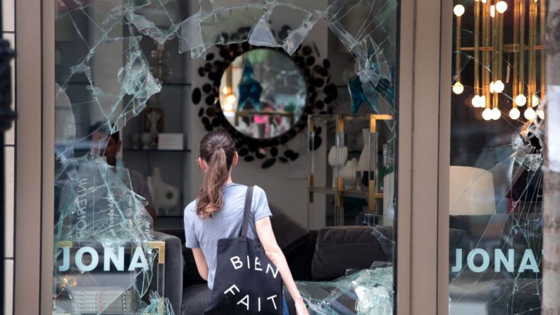  Una mujer mira a través de la ventana de vidrio roto de la tienda de diseño interior de Jonathan Adler que fue saqueada el 10 de agosto de 2020 en Chicago, Illinois.(Scott Olson/Getty Images)
