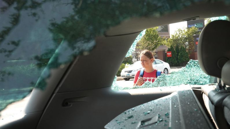 La gente pasa por delante del aparcamiento de coches usados de Car Source donde se informó de que una persona había sido herida de bala por un vigilante durante una tercera noche de disturbios el 26 de agosto de 2020 en Kenosha, Wisconsin.  (Scott Olson/Getty Images)