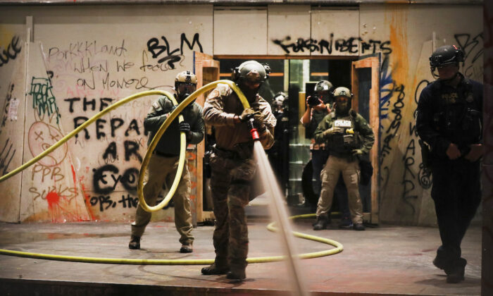 Agentes federales limpian frente al tribunal federal Mark O. Hatfield en el centro de Portland en Portland, Oregon, el 28 de julio de 2020. (Spencer Platt/Getty Images)