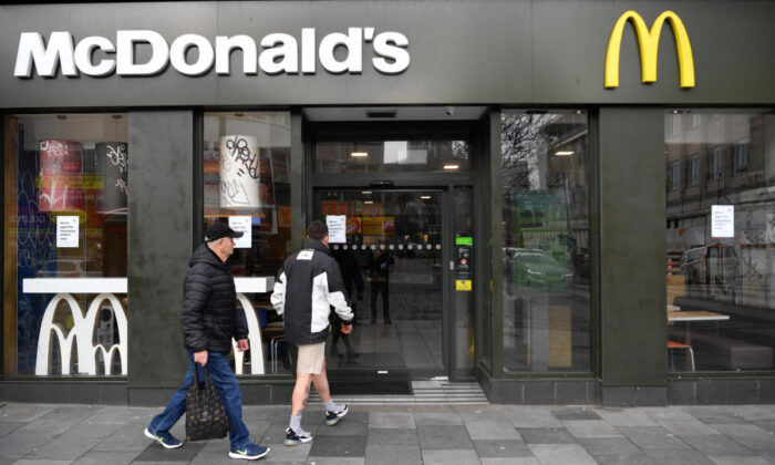 Dos personas entran en un restaurante de McDonalds donde sólo se ofrecía comida para llevar debido al virus del PCCh en Plymouth, Reino Unido, el 19 de marzo de 2020. (Dan Mullan/Getty Images)