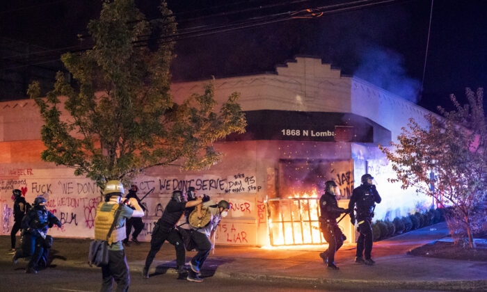 La policía de Portland dispersa a una multitud después de que varios manifestantes incendiaran el edificio de la Asociación de Policía de Portland (PPA) el 29 de agosto de 2020 en Portland, Oregon. (Nathan Howard/Getty Images)