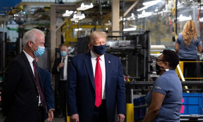 El presidente de Estados Unidos, Donald Trump (2° a la izquierda), usa una mascarilla mientras habla con un empleado y recorre la planta de fabricación de Whirlpool Corporation en Clyde, Ohio, el 6 de agosto de 2020 (Jim Watson/AFP a través de Getty Images)
