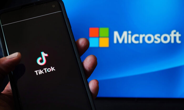 En esta foto ilustrativa, un teléfono móvil con la aplicación TikTok aparece junto al logo de Microsoft en la ciudad de Nueva York el 3 de agosto de 2020. (Cindy Ord/Getty Images)