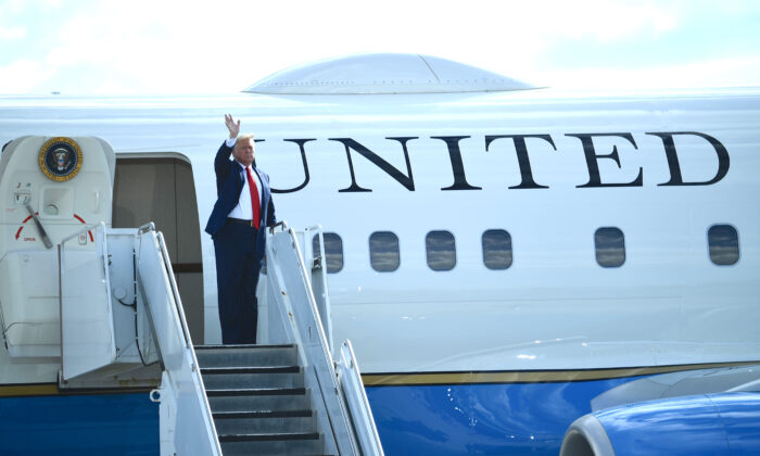 El presidente Donald Trump saluda desde el Air Force One en un hangar de aeropuerto en Oshkosh, Wisconsin, el 17 de agosto de 2020. (Brendan Smialowski/AFP a través de Getty Images)