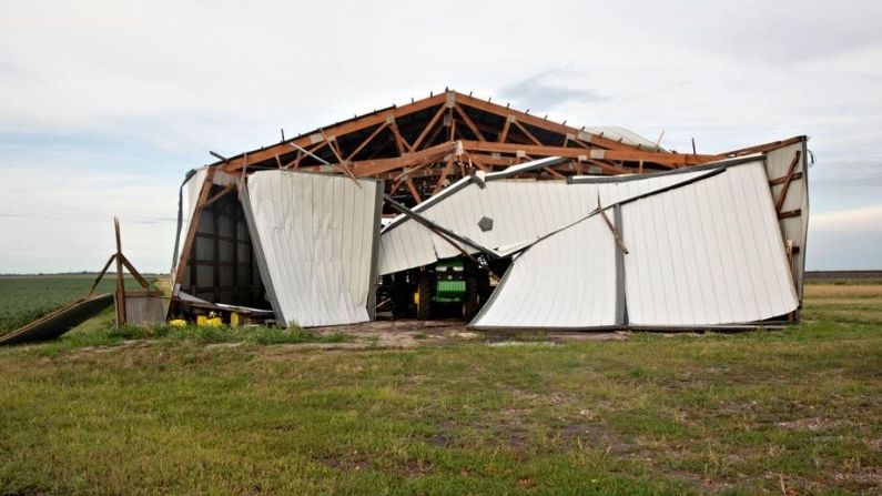 Un tractor agrícola John Deere se encuentra debajo de un edificio derrumbado después de la tormenta Derecho, una tormenta de viento generalizada asociada a una banda de lluvias o tormentas eléctricas de rápido movimiento, el 10 de agosto de 2020 cerca de Franklin Grove, Illinois. La tormenta se desplazó a través del Medio Oeste con vientos registrados cerca de 100 mph en Iowa e Illinois. (Daniel Acker/Getty Images)