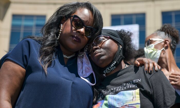 La representante Leslie Herod (D-Colo.) (L) abraza a la madre de Elijah McClain, Sheneen McClain (R) mientras se unen a los manifestantes que se reúnen frente a la sede del Departamento de Policía de Aurora para exigir justicia para el hijo de McClain en Aurora, Colorado, el 27 de junio de 2020. ( Michael Ciaglo/Getty Images)
