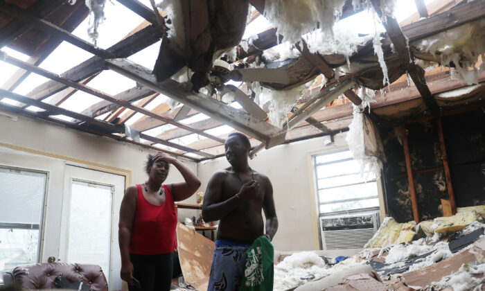 Latasha Myles y Howard Anderson están de pie en su sala, donde estaban sentados cuando el techo se voló cerca de las 2:30 a.m. cuando el huracán Laura pasó por el área en Lake Charles, La., el 27 de agosto de 2020. (Joe Raedle/Getty Images)