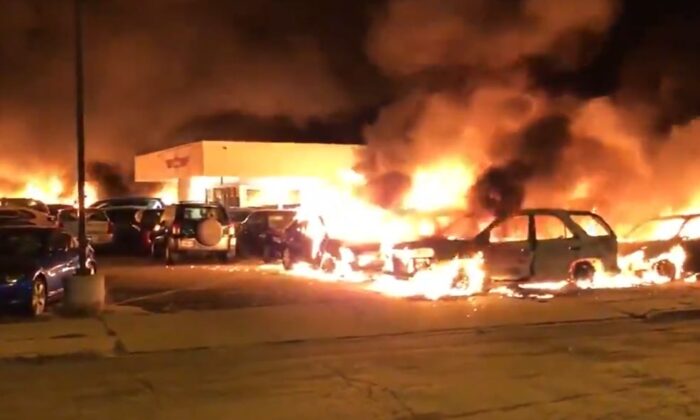 Las llaman calcinan un concesionario de autos que fue incendiado como consecuencia de los disturbios que tuvieron lugar en Kenosha (Wisconsin) durante la madrugada del 24 de agosto de 2020. (Drew Hernandez/@livesmattershow)