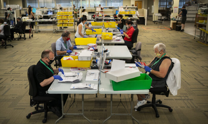 Los trabajadores electorales procesan las boletas electorales por correo para las elecciones primarias de Washington en la sede de King County Elections en Renton, Washington, el 4 de agosto de 2020. (David Ryder/Getty Images)