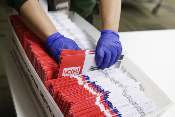 Los trabajadores electorales clasifican las boletas de voto por correo para la primaria presidencial en las elecciones del condado de King en Renton, Washington, el 10 de marzo de 2020. (Jason Redmond/AFP vía Getty Images)
