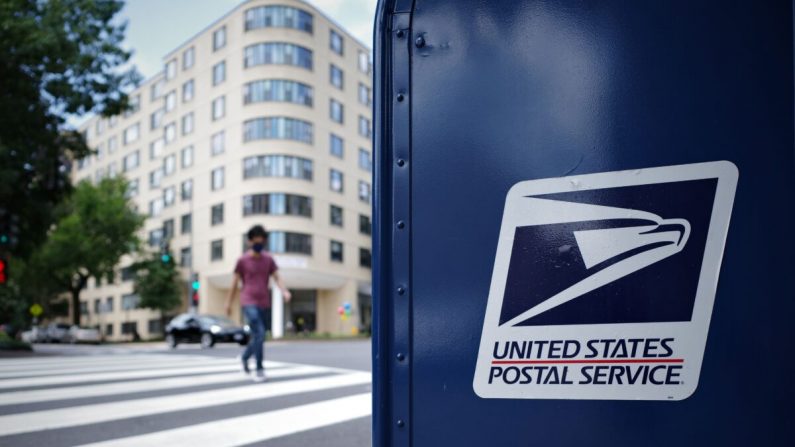 Un hombre cruza una intersección junto a un buzón del Servicio Postal de EE. UU. en Washington el 17 de agosto de 2020. (Mandel Ngan/AFP a través de Getty Images)