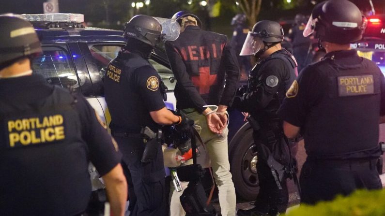 La policía de Portland arrestó a un autodenominado médico durante los disturbios de Portland, Oregón, a principios del 21 de agosto de 2020. (Nathan Howard/Getty Images)
