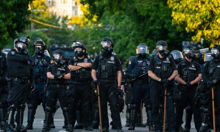 La policía bloquea una carretera durante las protestas cerca de la Comisaría Este de la Policía de Seattle, Wash., el 26 de julio de 2020. (David Ryder/Getty Images)