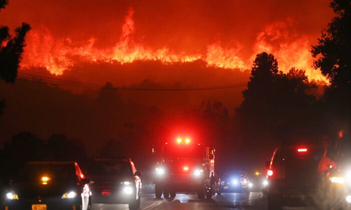 Las llamas del incendio del Lake Fire avanzan por una ladera cerca de un camión de bomberos y otros vehículos en el Lago Hughes, California, el 12 de agosto de 2020. (Mario Tama/Getty Images)