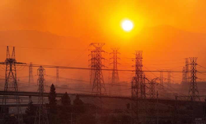 El sol se eleva sobre las líneas eléctricas a lo largo de un horizonte lleno de humo durante un incendio en Saddleridge, Newhall, California, el 11 de octubre de 2019. (Josh Edelson/AFP vía Getty Images)