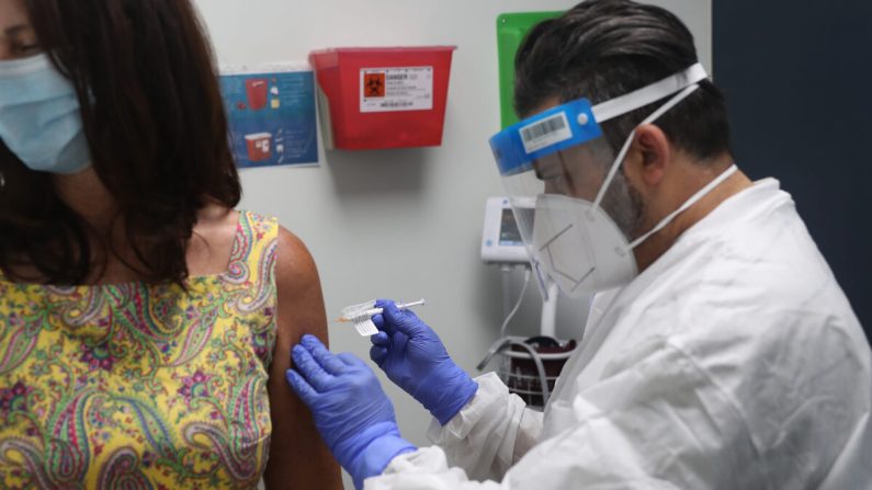 Un enfermero administra una vacuna contra el virus del PCCh a una voluntaria en los Centros de Investigación de EE.UU., en Hollywood, Florida, el 7 de agosto de 2020. (Joe Raedle/Getty Images)
