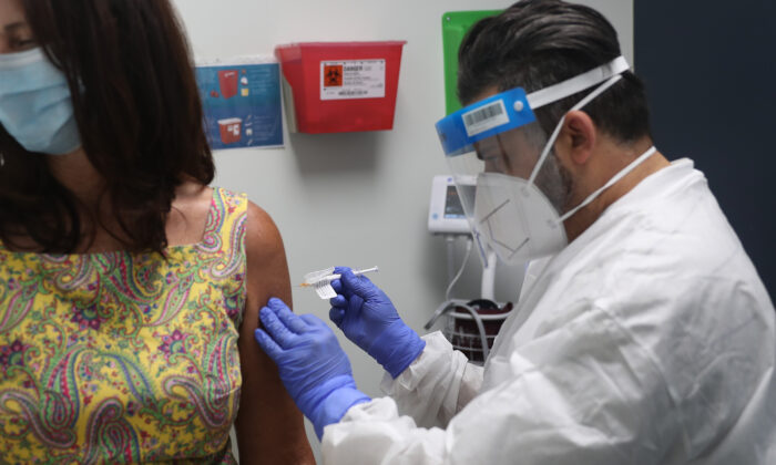 El enfermero José Muñiz administra una vacuna contra el virus del PCCh a una voluntaria en el Research Centers of America en Hollywood, Florida, el 7 de agosto de 2020. (Joe Raedle/Getty Images)