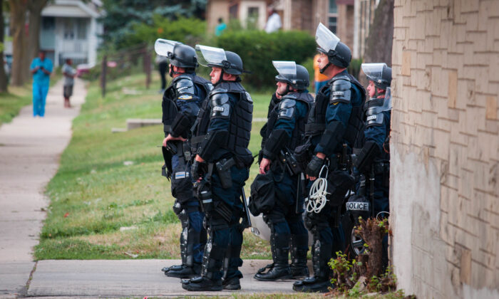 Varios policías con equipo antidisturbios vigilan un vecindario en Milwaukee, Wisconsin, el 15 de agosto de 2016. (Darren Hauck/Getty Images)