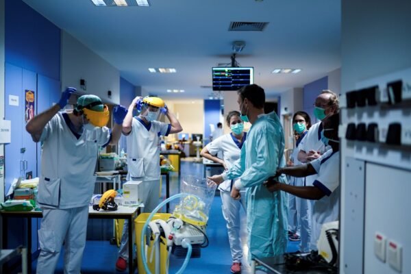 Varios trabajadores sanitarios se ponen el equipo de protección antes de trabajar en la unidad para pacientes infectados por COVID-19 en el Hospital Erasme de Bruselas, el 27 de marzo de 2020. (Kenzo Tribouillard/AFP vía Getty Images)