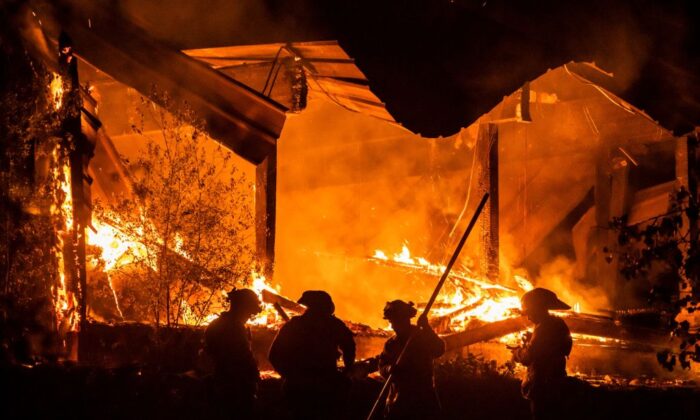 Bomberos trabajando frente a una estructura perdida durante el incendio de Kincade, en la autopista 128, al este de Healdsburg, California, el 29 de octubre de 2019. (Philip Pacheco/AFP a través de Getty Images).