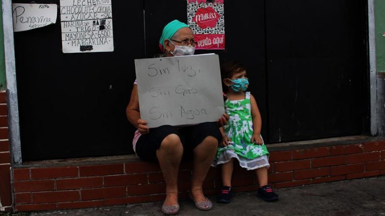 Una mujer sostiene un letrero reclamando la falta de agua, gas y electricidad a modo de protesta, el 23 de septiembre de 2020, en San Cristóbal (Venezuela). EFE/Johnny Parra