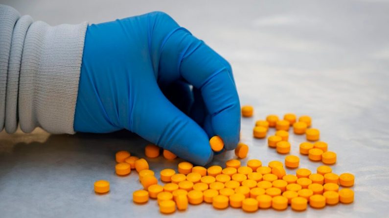 Un químico de la Administración para el Control de Drogas (DEA) revisa pastillas que contienen fentanilo en el Laboratorio Regional Noreste de la DEA en Nueva York el 8 de octubre de 2019 (Don Emmert/AFP a través de Getty Images)
