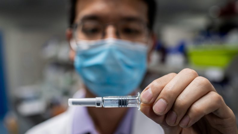 Un ingeniero muestra una vacuna experimental para el coronavirus COVID-19 que se probó en el Laboratorio de Control de Calidad en las instalaciones de Sinovac Biotech en Beijing el 29 de abril de 2020. (NICOLAS ASFOURI/AFP a través de Getty Images)